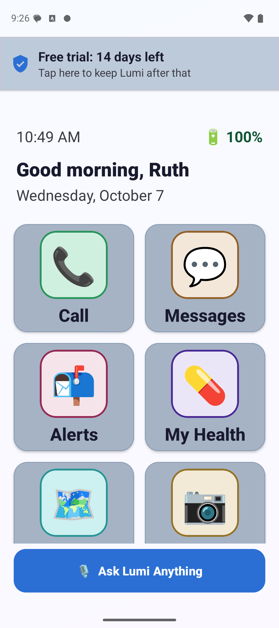 The Lumi home screen: a greeting reading Good morning Ruth, the date, the time and battery level, and large tiles labeled Call, Messages, Alerts, My Health, Directions and Camera, with a wide Ask Lumi Anything button along the bottom.